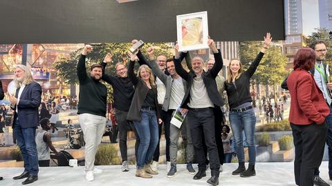 Eine Gruppe von Menschen mit dem Polis-Award und der gerahmten Urkunde (Mitte: Dr. Britta Freis, Leiterin Projektbüro Haus des Wissens)