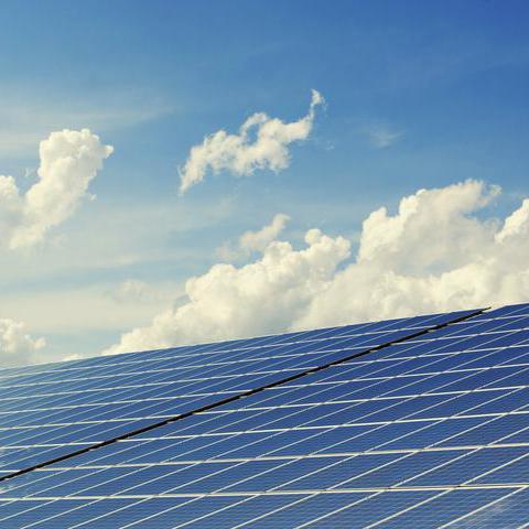 Photovoltaikanlage mit blauem Himmel und Wolken im Hintergrund