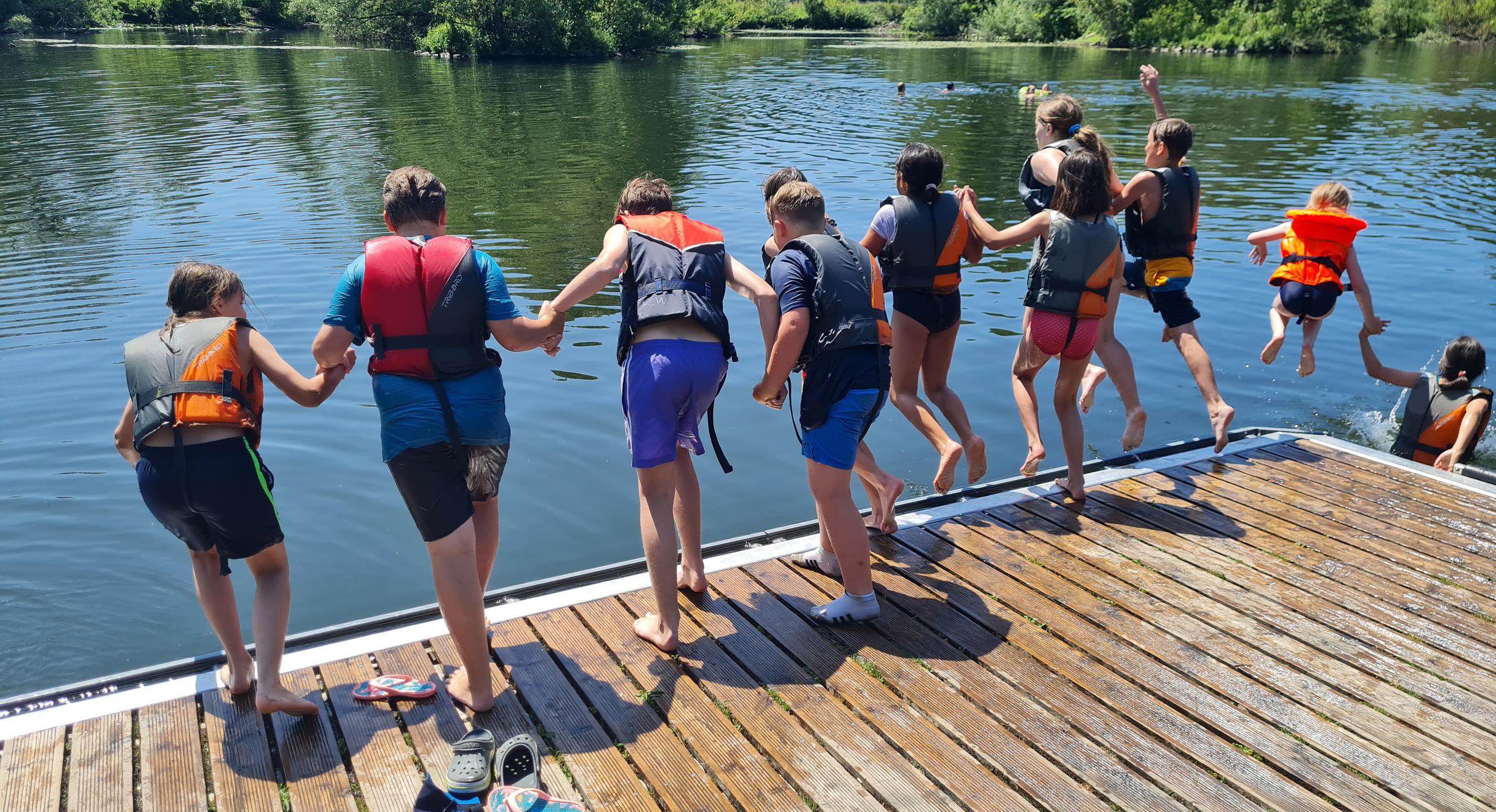 Kinder die ins Wasser springen 