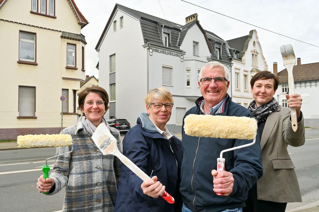 Dorothée Dahl von der Stadt Bochum, Angelika und Achim Vetter als Hauseigentümer sowie Architektin Katja Schlemper halten Pinsel und Farbroller in der Hand.