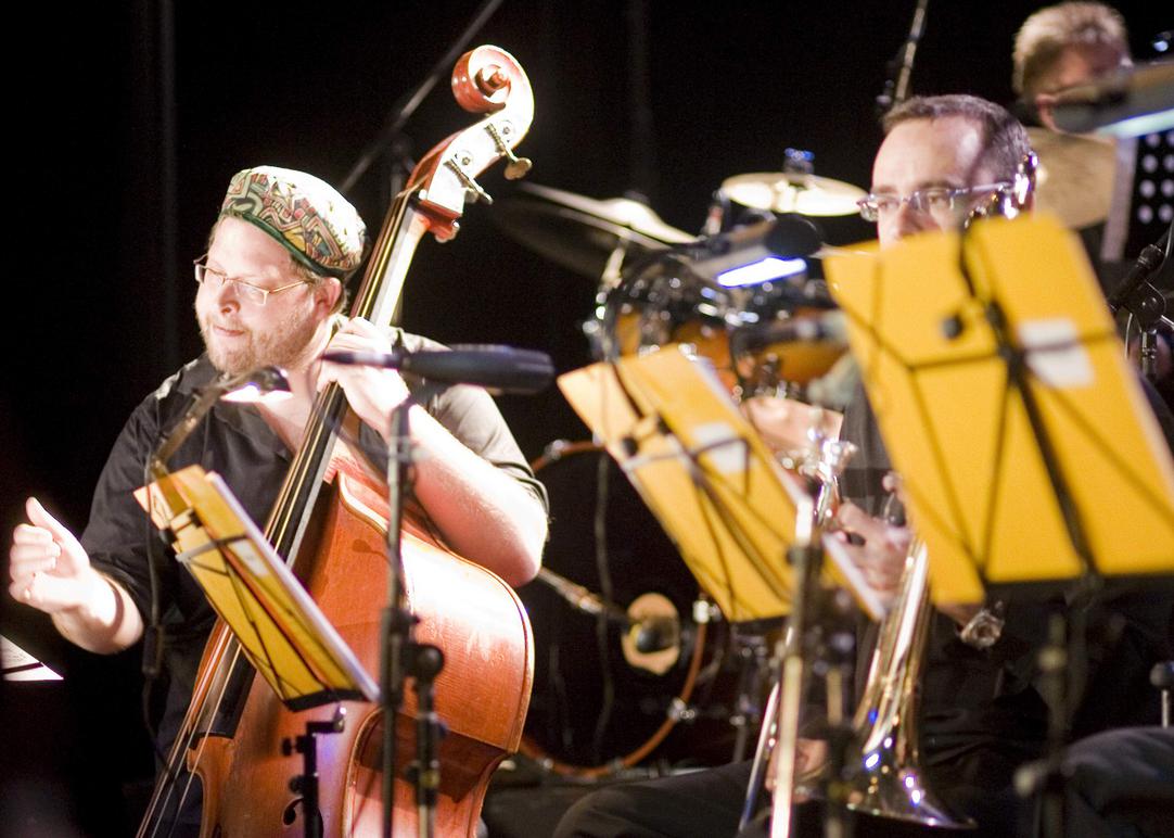 Ein Mann spielt Cello auf einer Bühne.