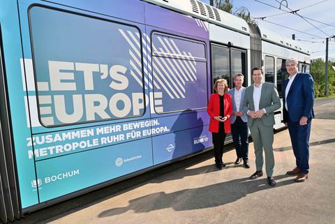 Karin Welge, Jörg Filter, Thomas Eiskirch und Markus Schlüter stehen vor einer Straßenbahn der BOGESTRA mit dem Slogan Let´s Europe.