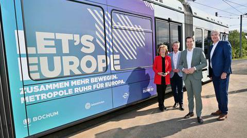 Karin Welge, Jörg Filter, Thomas Eiskirch und Markus Schlüter stehen vor einer Straßenbahn der BOGESTRA mit dem Slogan Let´s Europe.