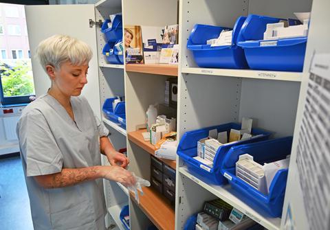 Eine Pflegerin zieht sich Einmalhandschuhe an. 