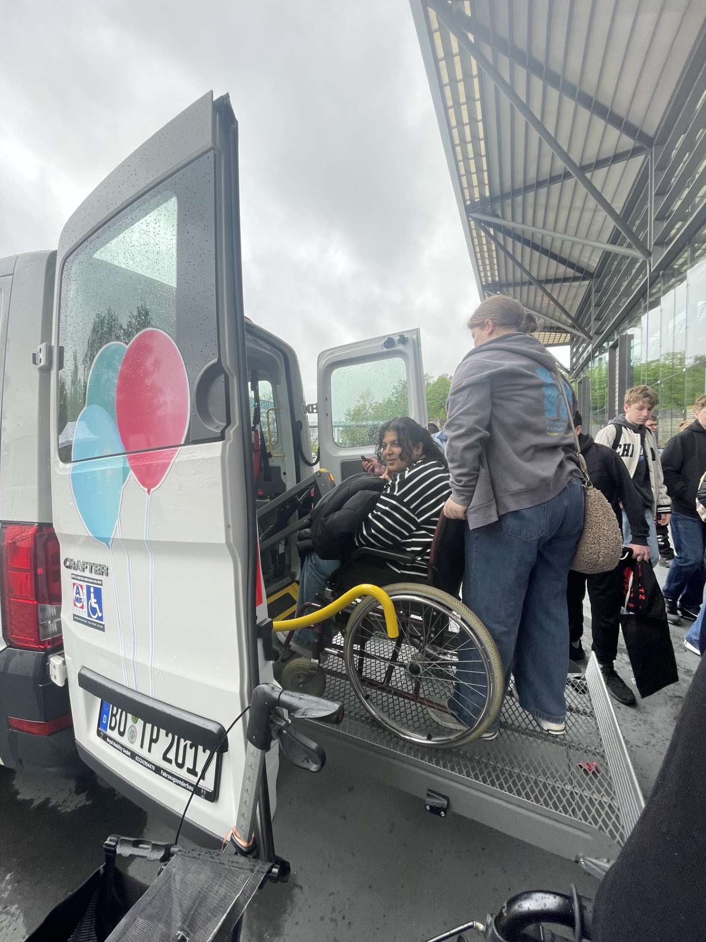 Ein Rollstuhlfahrer wird in einen Bully geladen