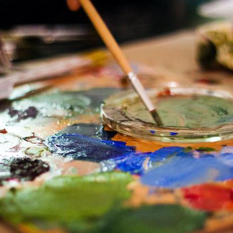 Eine Mischpalette mit Farben und Pinsel.