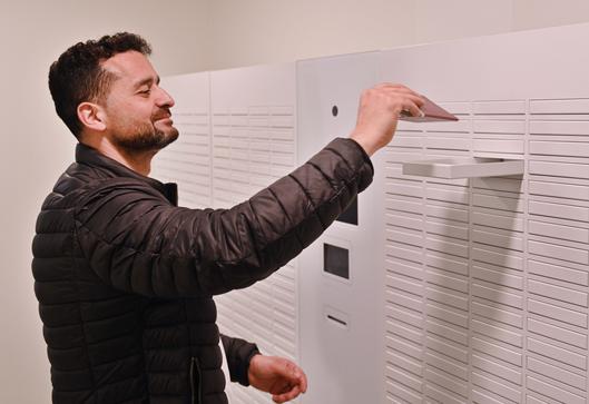 Ein Mann holt seinen Reisepass aus der Dokumentenausgabebox.