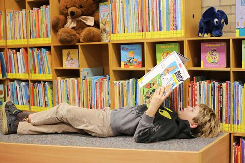 Ein Kind liest ein Buch in der Bücherei in Bochum-Wiemelhausen. 