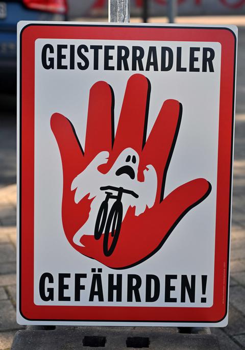 Ein Rot-Weißes Schild mit der Aufschrift "Geisterradler Gefährden" und einem Geist auf dem Fahrrad