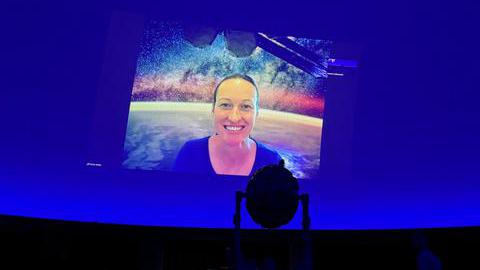 Das Bild zeigt Astronautin Nicola Berger über eine Videokonferenz zugeschaltet auf blauem Hintergrund. 
