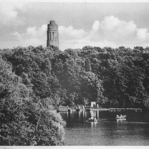 Gondelteich mit Paddelbooten, im Hintergrund ein Wald und der Bismarckturm.
