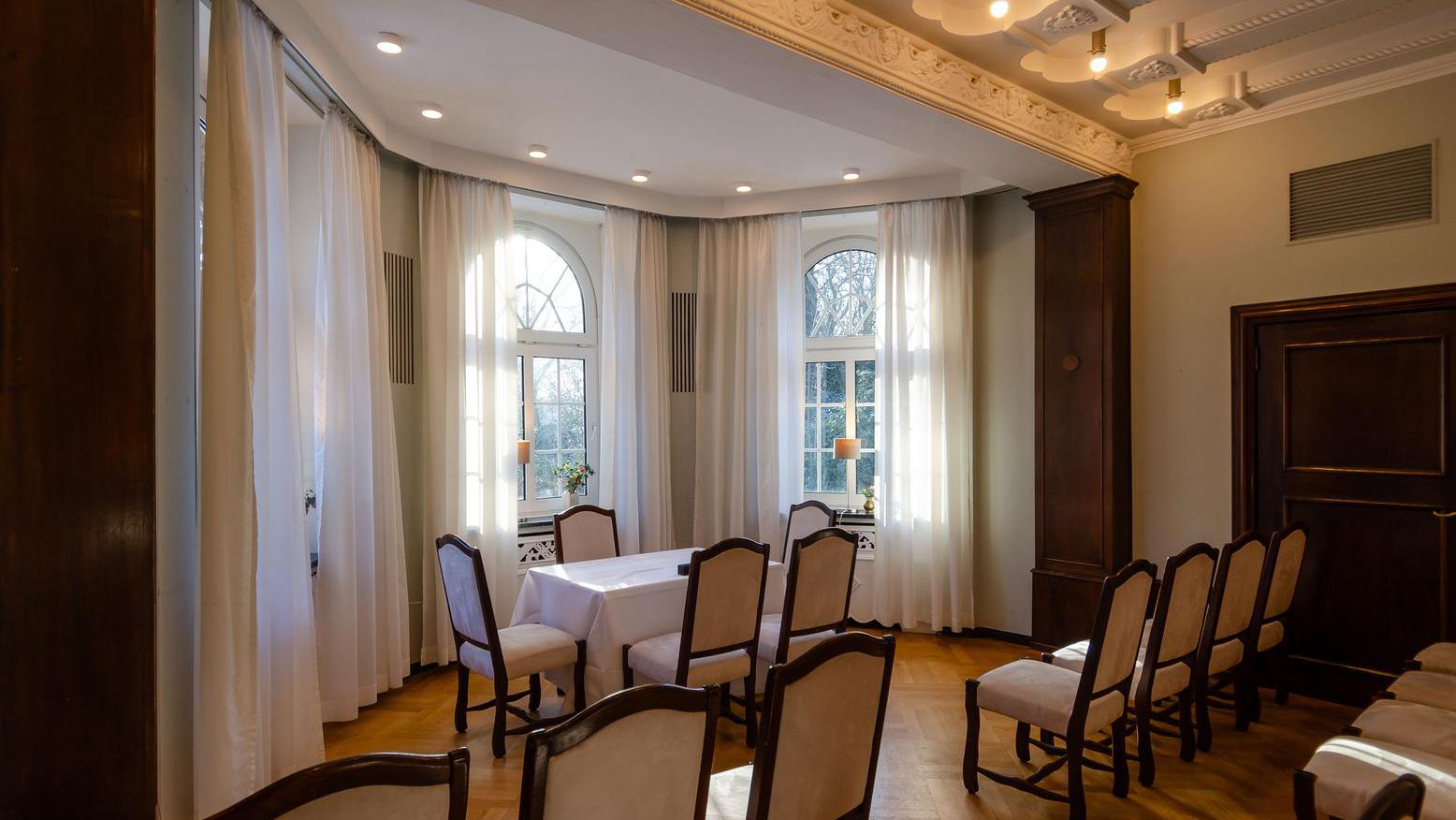 Das Trauzimmer Gesellschaft Harmonie ist sehr groß und bietet der Hochzeitsgesellschaft viele Sitzmöglichkeiten. Vorne im Raum steht ein Tisch, an dem Brautpaare getraut werden. 