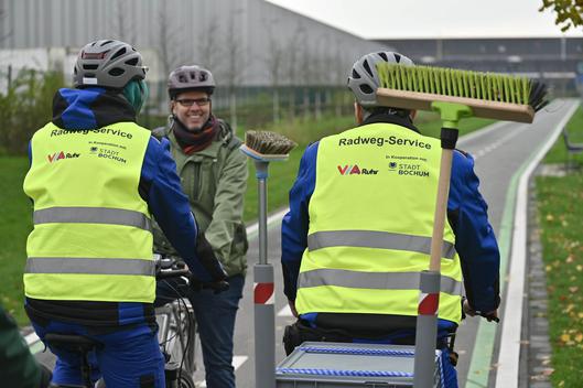 Drei Personen die auf Fahrrädern aneinander vorbei fahren.