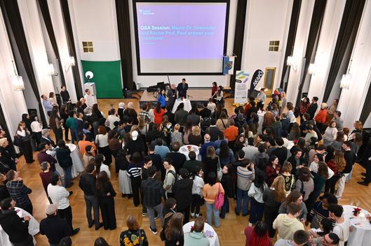 Versammlung internationaler Studenten in einem Saal.
