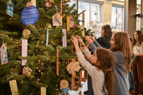 Kinder aus der Kunstvermittlung des Kunstmuseum Bochum und Oberbürgermeister Thomas Eiskirch schmücken am 28.11.2024 einen Weihnachtsbaum im Foyer des Rathauses in Bochum.