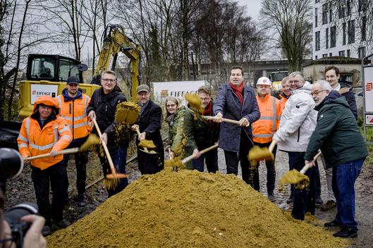 Oberbürgermeister Thomas Eiskirch und Mitglieder der Bezirksregierung Arnsberg, der Politik und Verwaltung sowie der ausführenden Baufirma beim Spatenstich für den neuen Radweg.