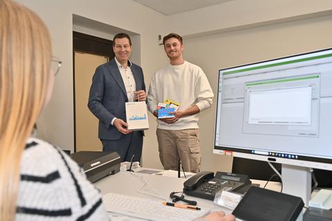 Cedric Padeken erhält am 02.01.2025 nach seiner Ummeldung im Bürgerbüro von Oberbürgermeister Thomas Eiskirch eine Neubürgertasche überreicht.