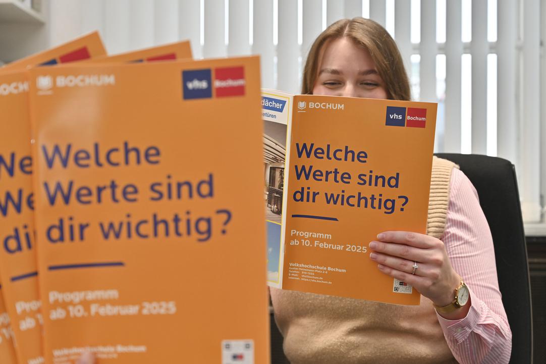 Frau mit neuem VHS-Programm in der Hand