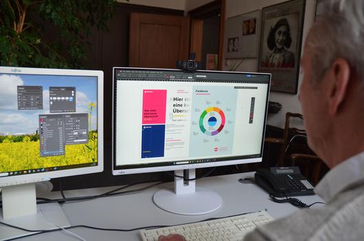 Ein Mann erstellt an einem PC Broschüren im Corporate Design der Stadt Bochum.