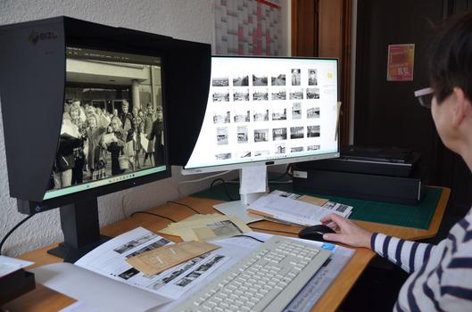 Eine Frau sichtet Fotos am PC.