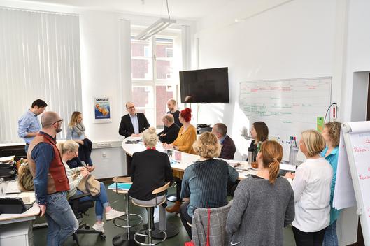 Ein Foto von einem Raum, in dem viele Personen versammelt sind.