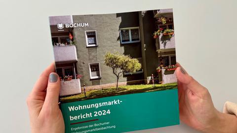 Hände mit der Broschüre Wohnungsmarktbericht