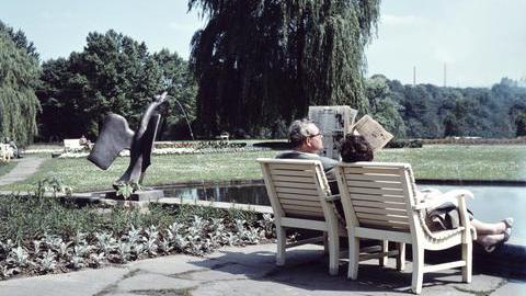 Ein Bild aus den 1960er Jahren im Stadtpark Bochum. Ein Ehepaar sitzt auf einer weißen Bank am Gondelteich.