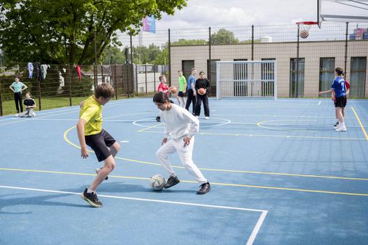 Spielende Kinder auf einem Kleinspielfeld.