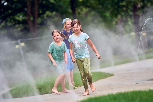 Spielende Kinder auf dem neuen Wasserspielplatz im Stadtpark