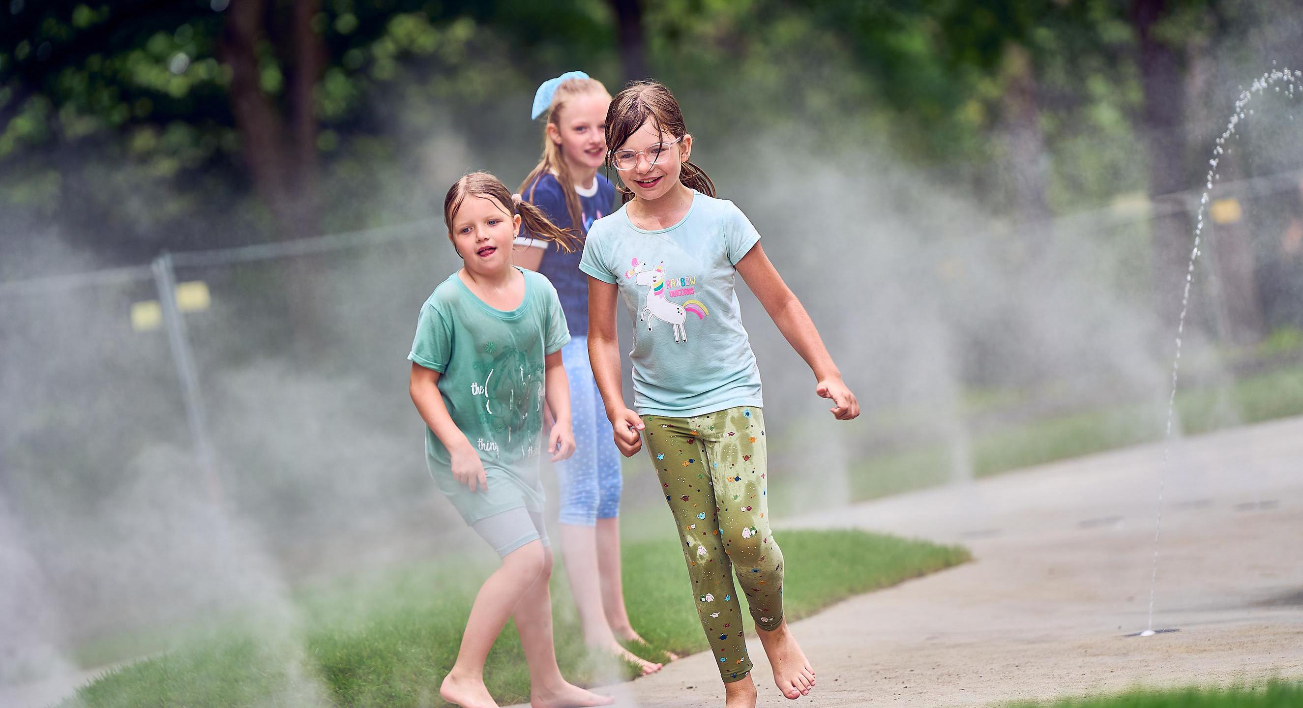 Spielende Kinder auf dem neuen Wasserspielplatz im Stadtpark