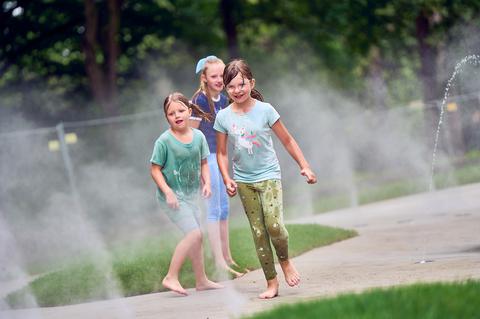 Spielende Kinder auf dem neuen Wasserspielplatz im Stadtpark