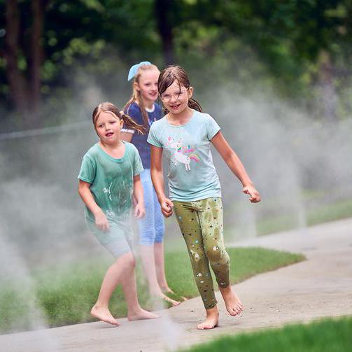 Spielende Kinder auf dem neuen Wasserspielplatz im Stadtpark