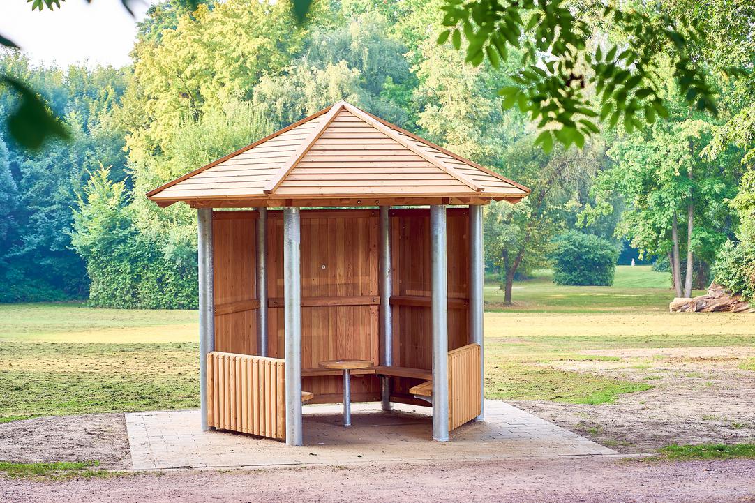 Das Bild zeigt die Mitmachhütte in Hamme an einem Weg neben einer Wiese und Bäumen.