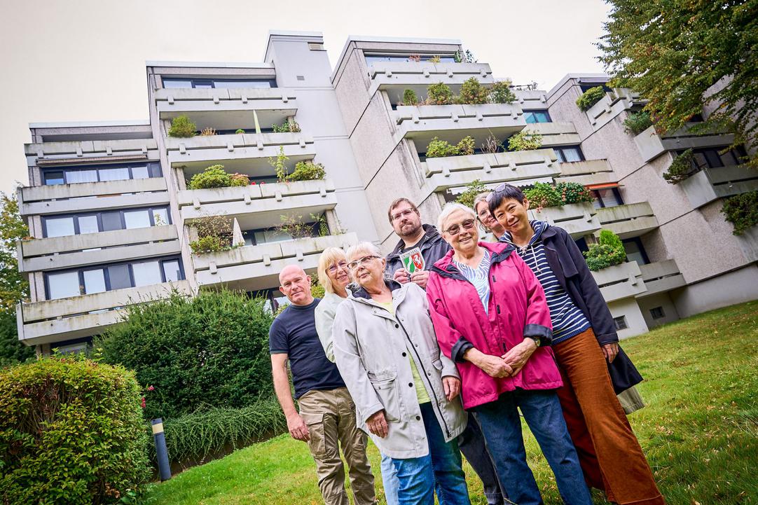 Vertreter*innen der Eigentümergemeinschaft vor dem Terrassenhaus an der Schattbachstraße bei der Übergabe der Denkmalplakette
