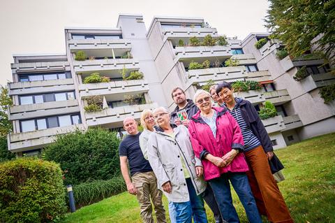 Vertreter*innen der Eigentümergemeinschaft vor dem Terrassenhaus an der Schattbachstraße bei der Übergabe der Denkmalplakette