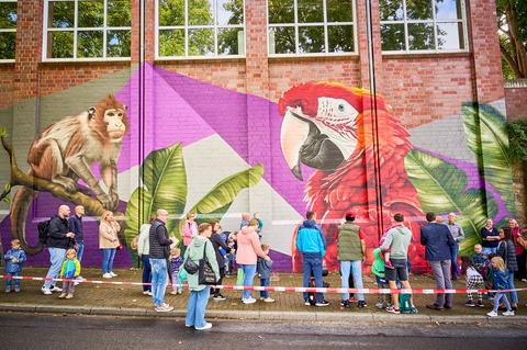 Eltern und Kinder besichtigen die Kunst an der Wand