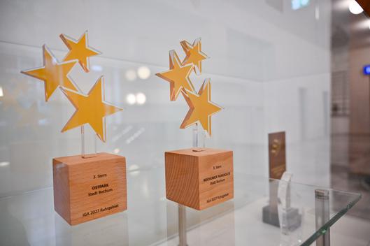 Zwei Preise, die aus drei Sternen bestehen, die auf einem Holzblock befestigt sind.