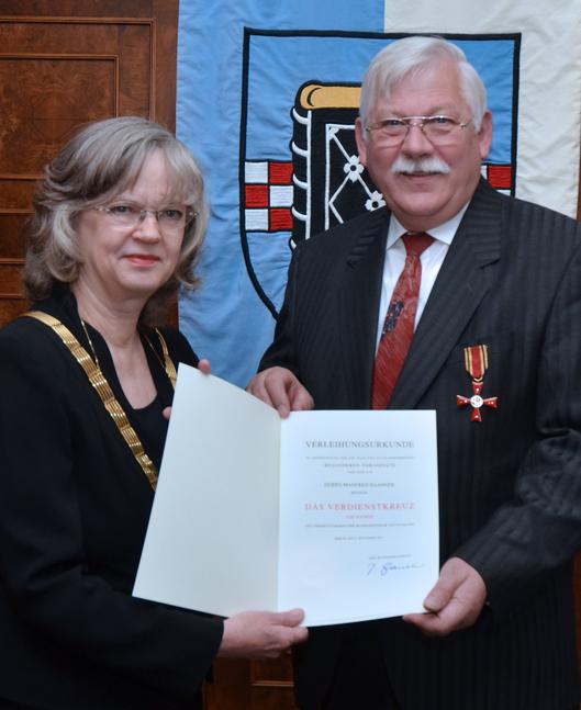 Übergabe der Urkunde des Verdienstordens an Manfred Baasner durch Ottilie Scholz 