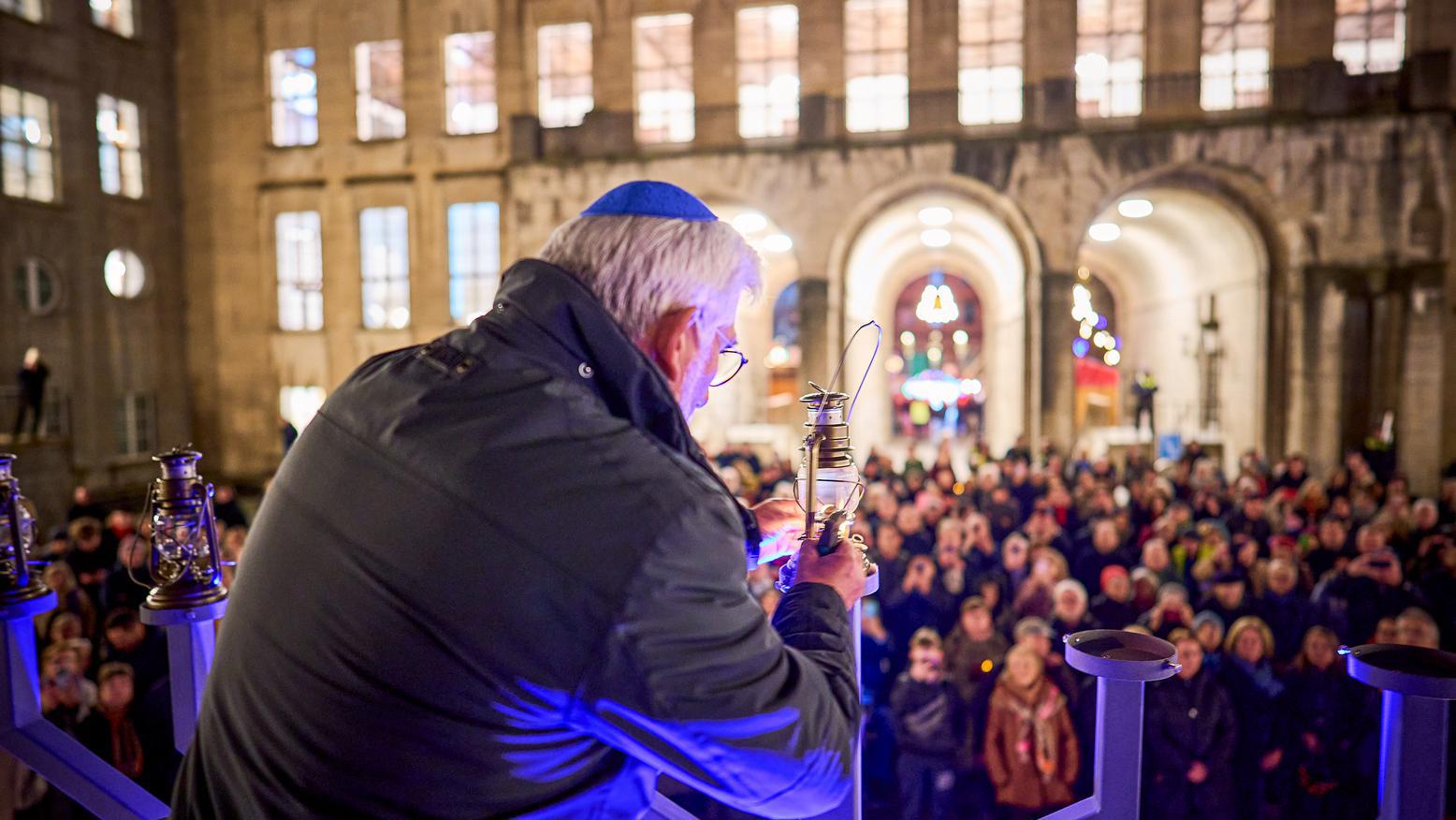 Oberbürgermeister Jörg Lukat entzündet die Lichter des achtarmigen Leuchters des jüdischen Lichterfestes