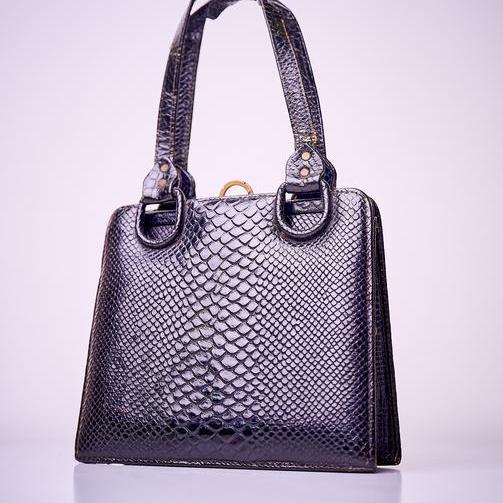 Eine schwarze Handtasche mit Schlangenlederprägung