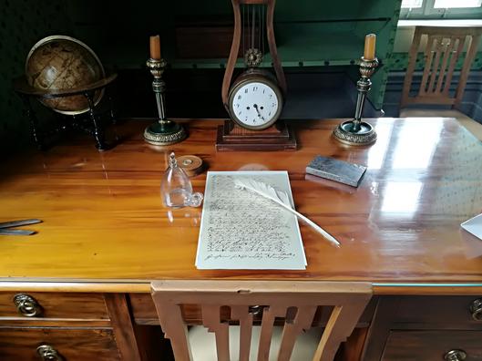 Historischer Schreibtisch mit Federkiel und Manuskript.