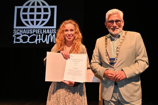 Yael Ronen präsentiert ihre Auszeichnung und Jörg Lukat steht neben ihr.