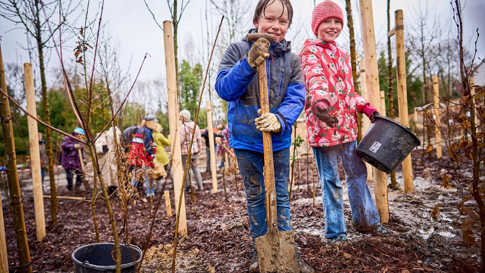 Das Bild zeigt zwei Kinder während des pflanzen der Setzlinge