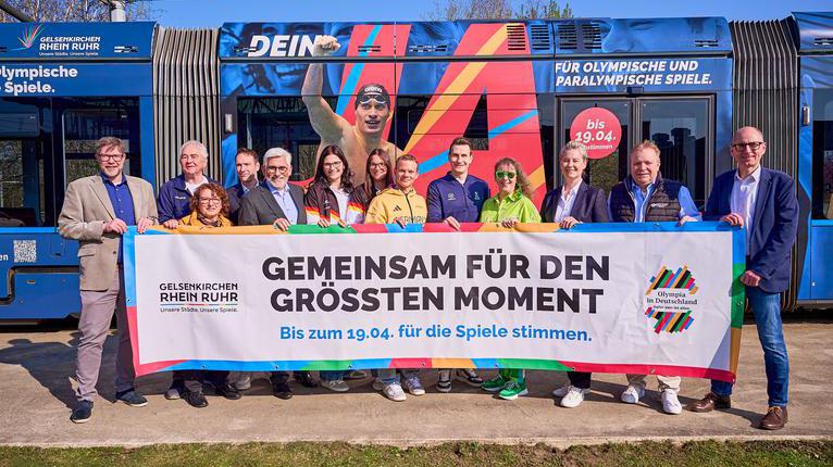 Ein Gruppenbild mit dem Aufruf um für die Spiele zu stimmen