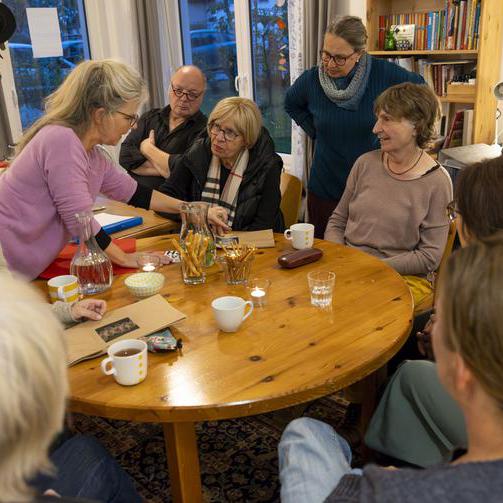 Mehrere Personen sitzen an einem Tisch und unterhalten sich.