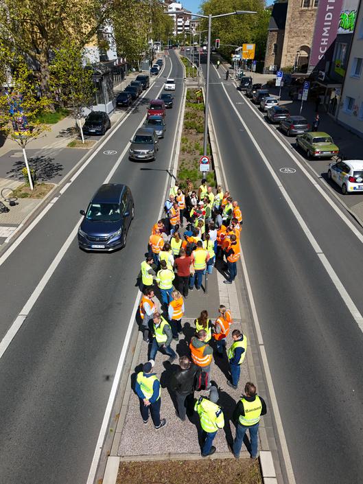 Eine Menschengruppe steht auf einem Verkehrsübergang.