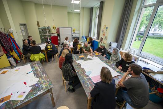 Personen sitzen an einem Tisch und unterhalten sich.