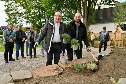 Zwei Männer bepflanzen ein Beet.