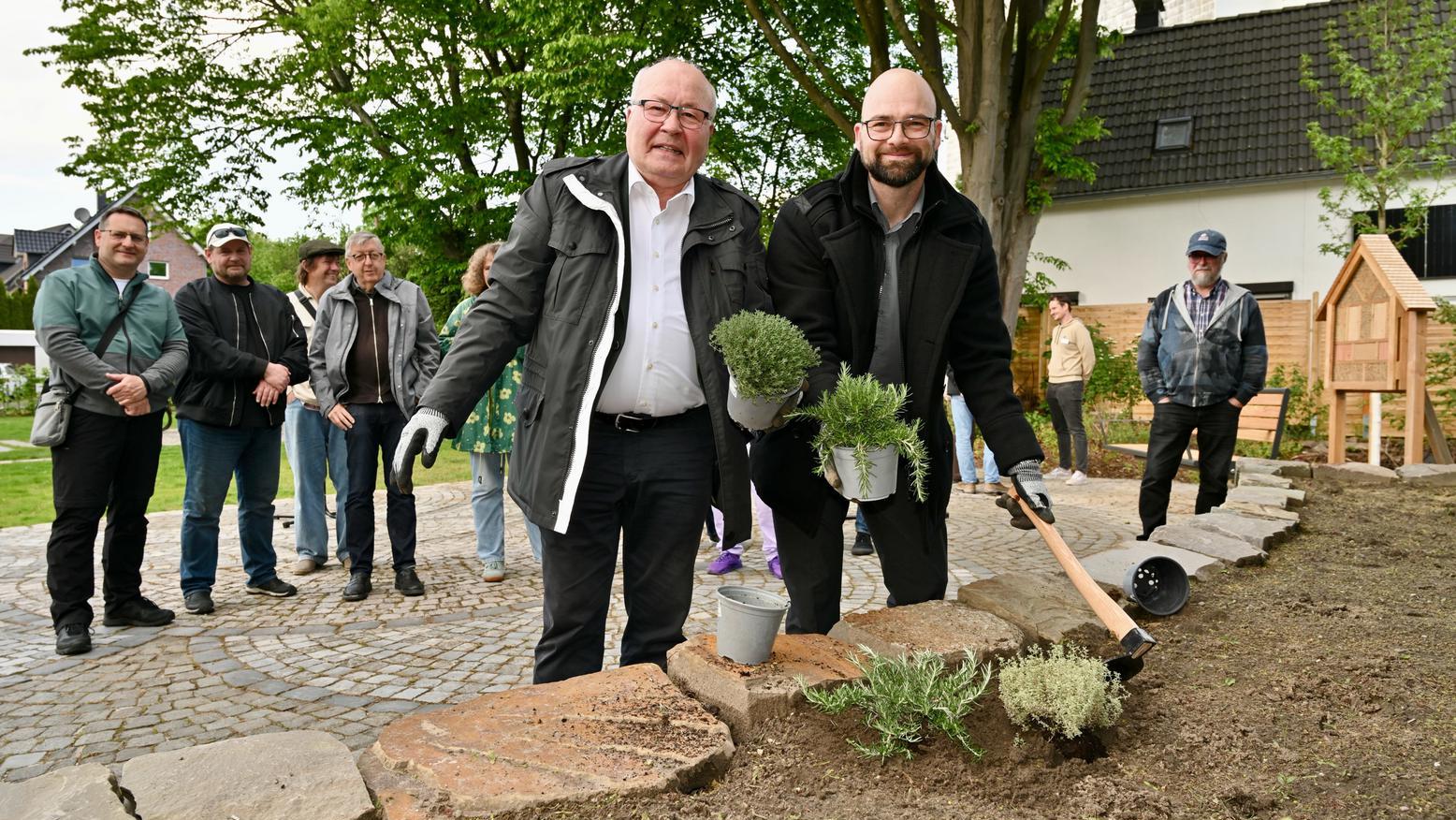 Zwei Männer bepflanzen ein Beet.