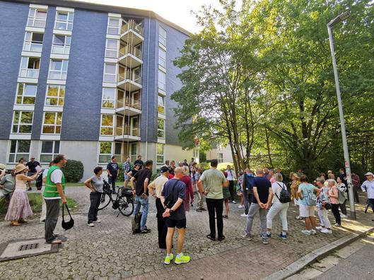 Eine Personengruppe hört dem Vortrag eines Mannes zu